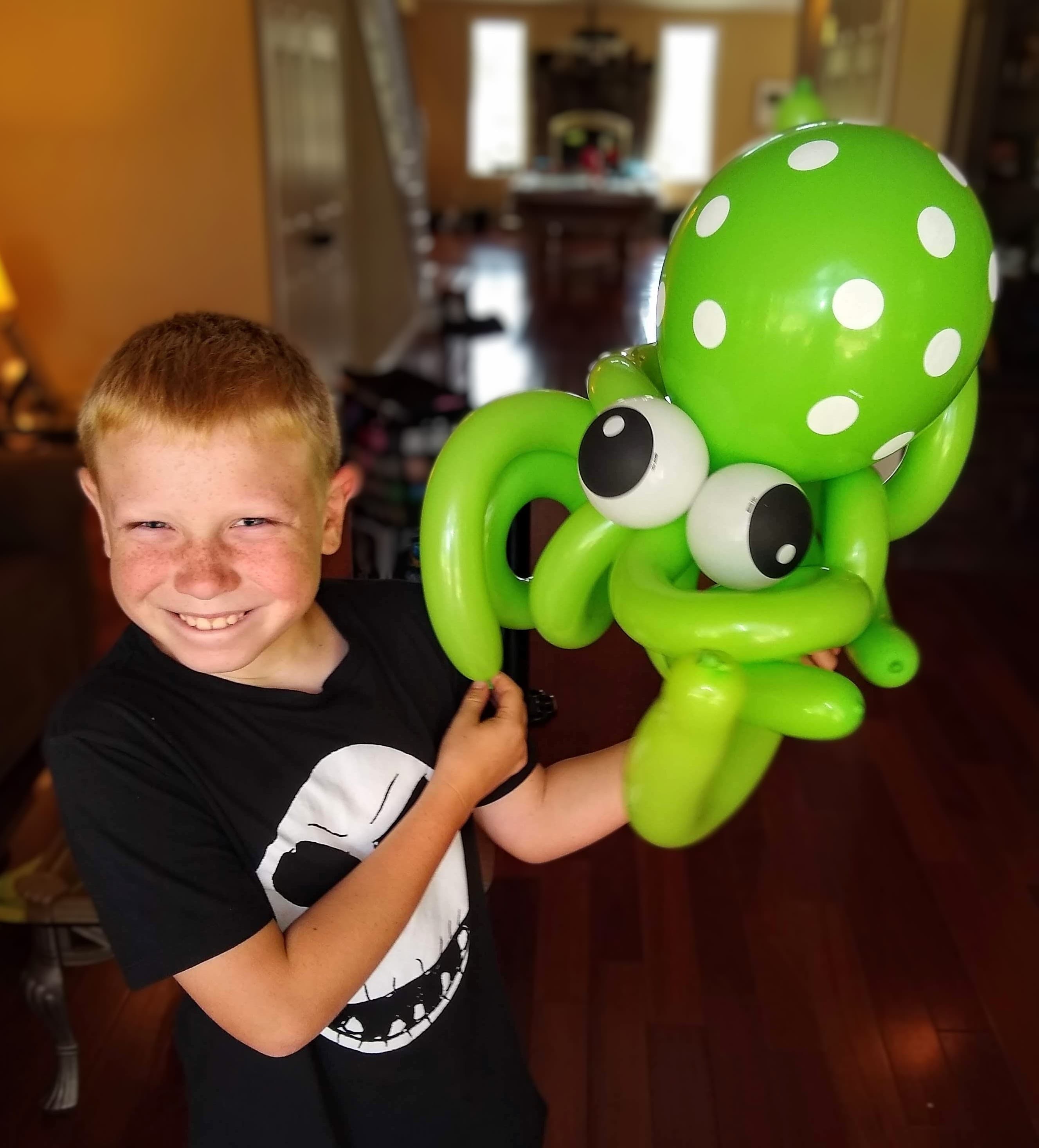 Boy with a green polka-dot balloon octopus