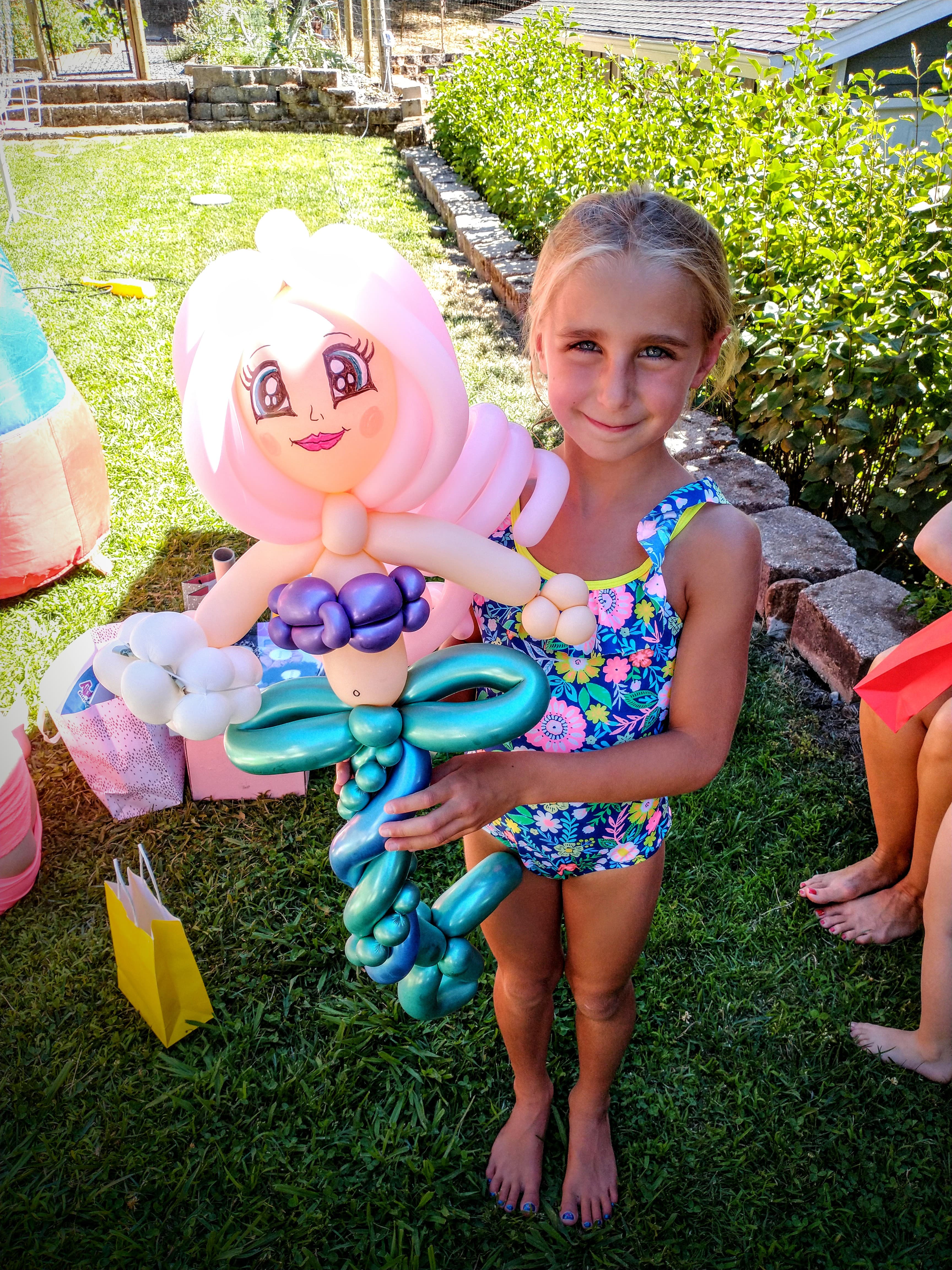 Girl holding a detailed mermaid balloon sculpture
