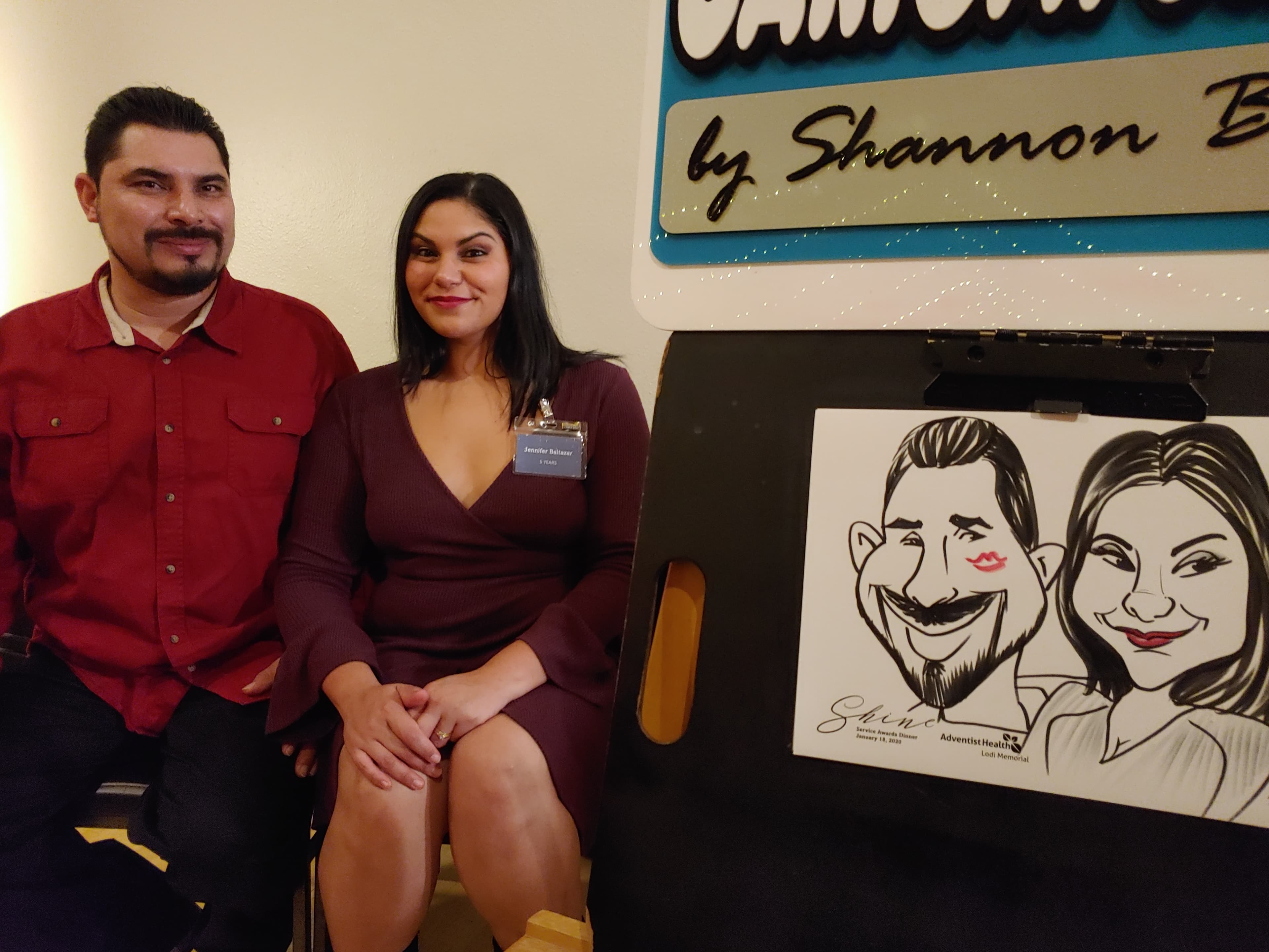 Corporate event guests with caricature on display