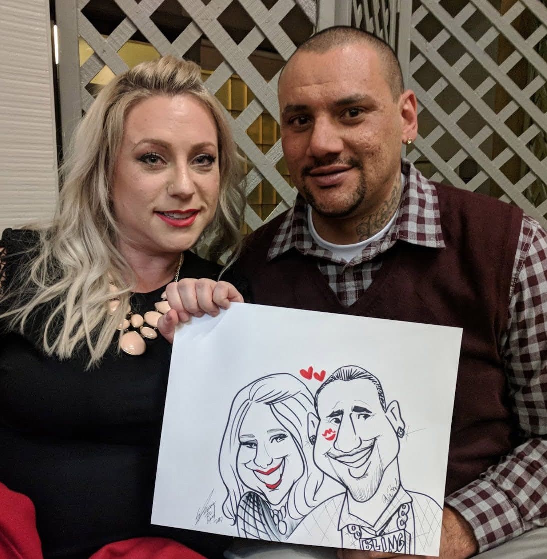 Couple holding their caricature drawing