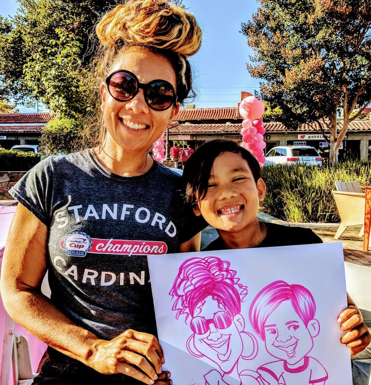 Mom and child with a pink-ink caricature outdoors