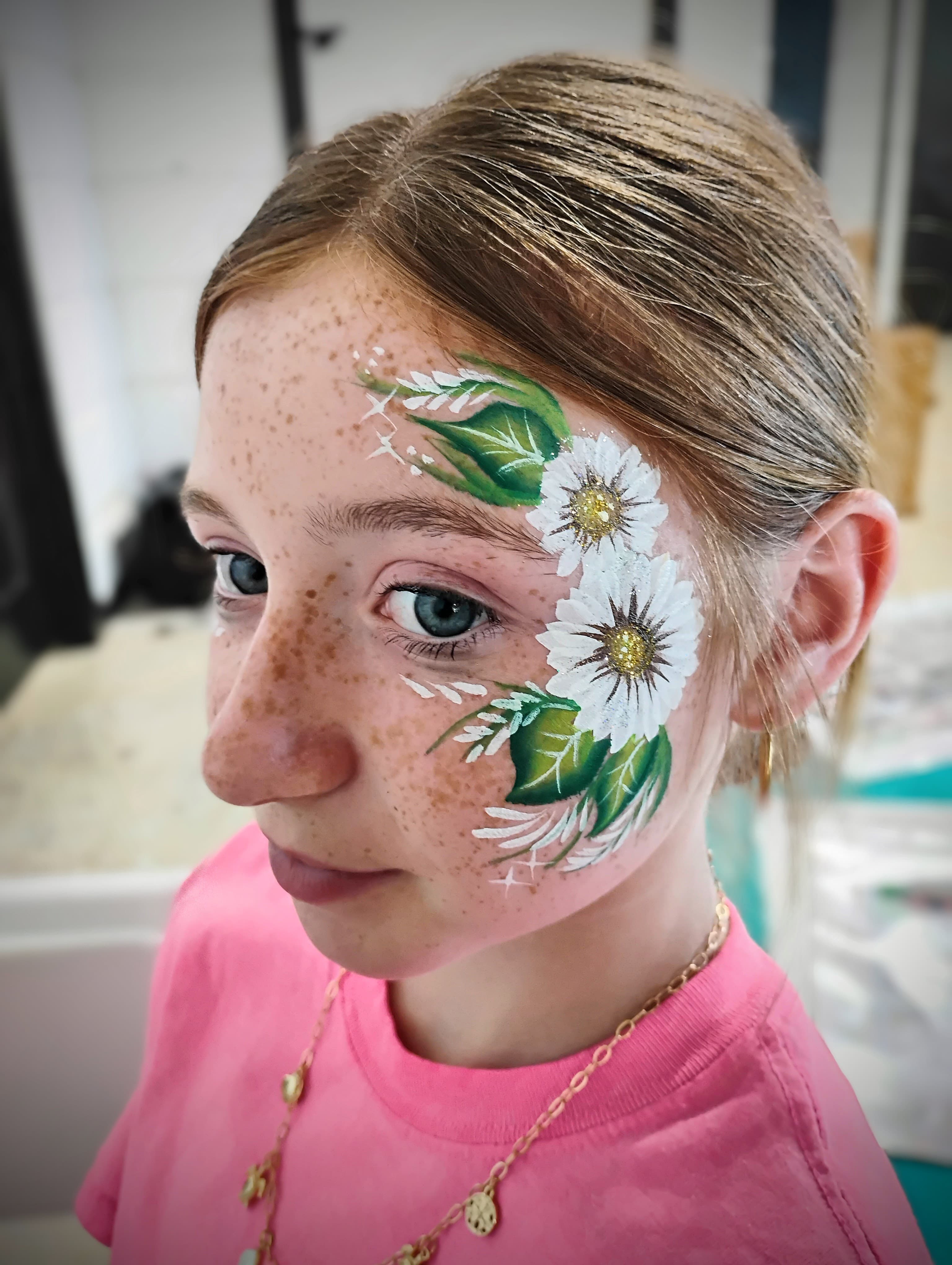 Girl with daisy flower face paint and glitter
