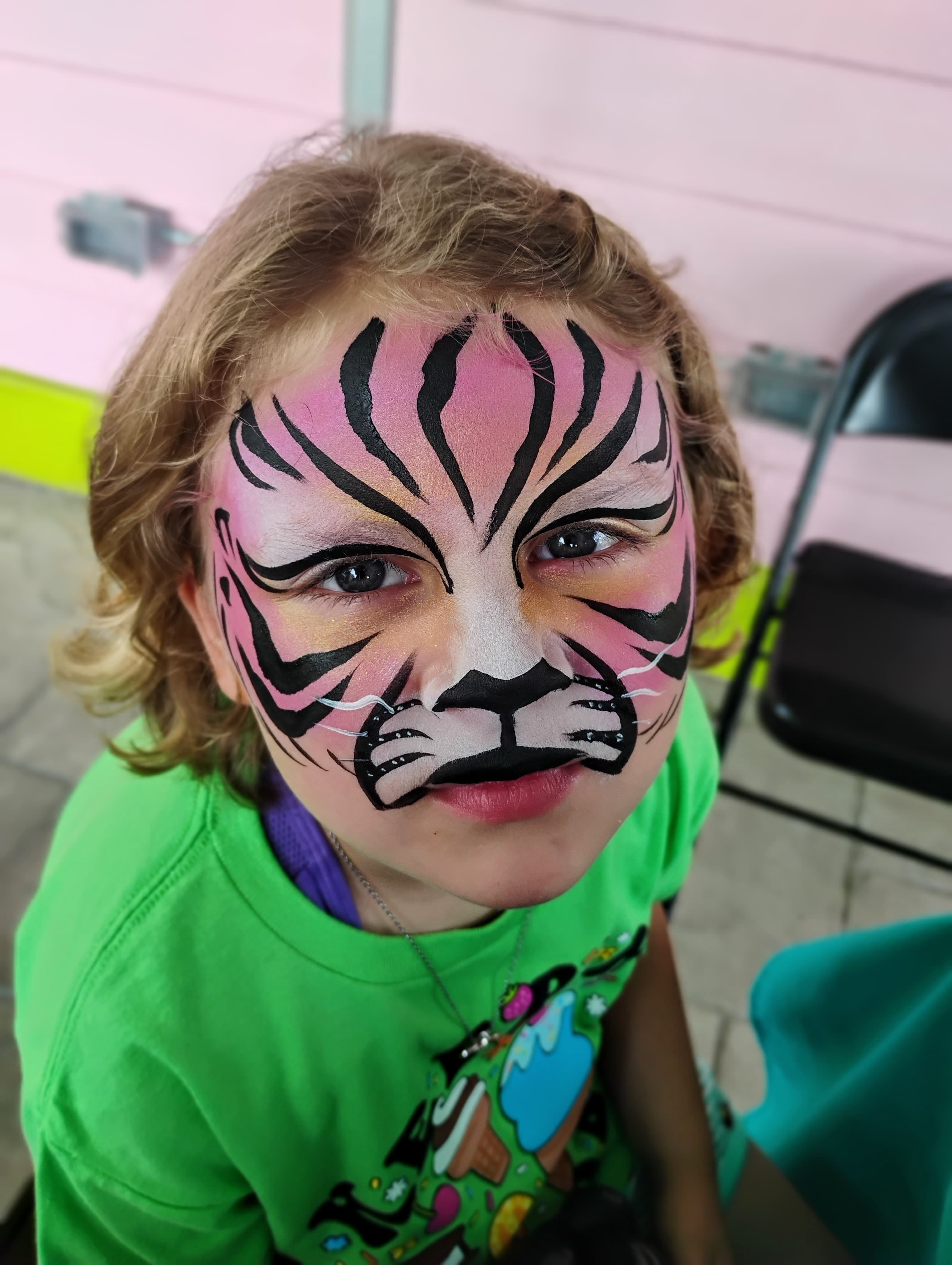 Child with pink and black tiger face paint