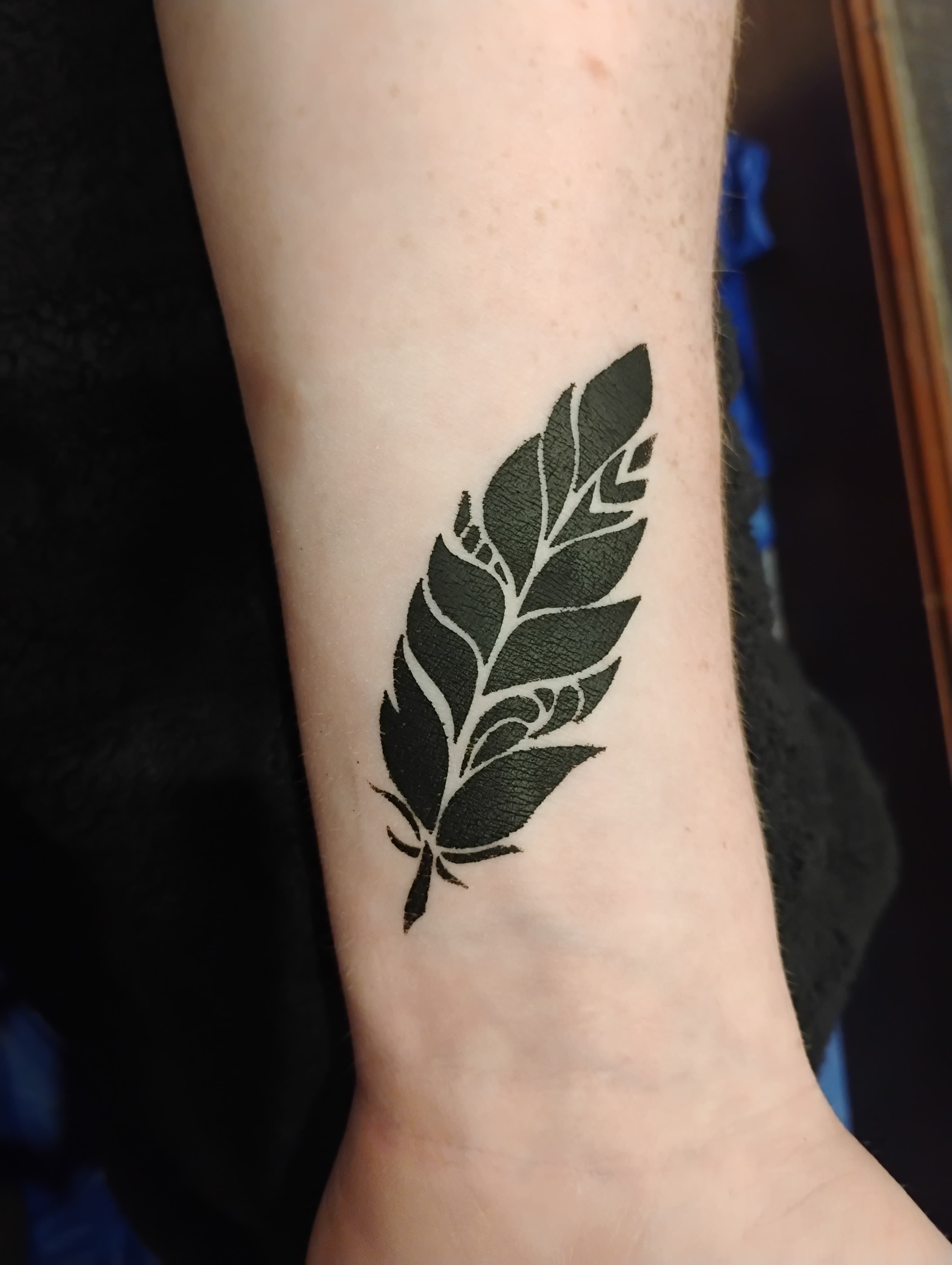 Black leaf temporary tattoo on forearm