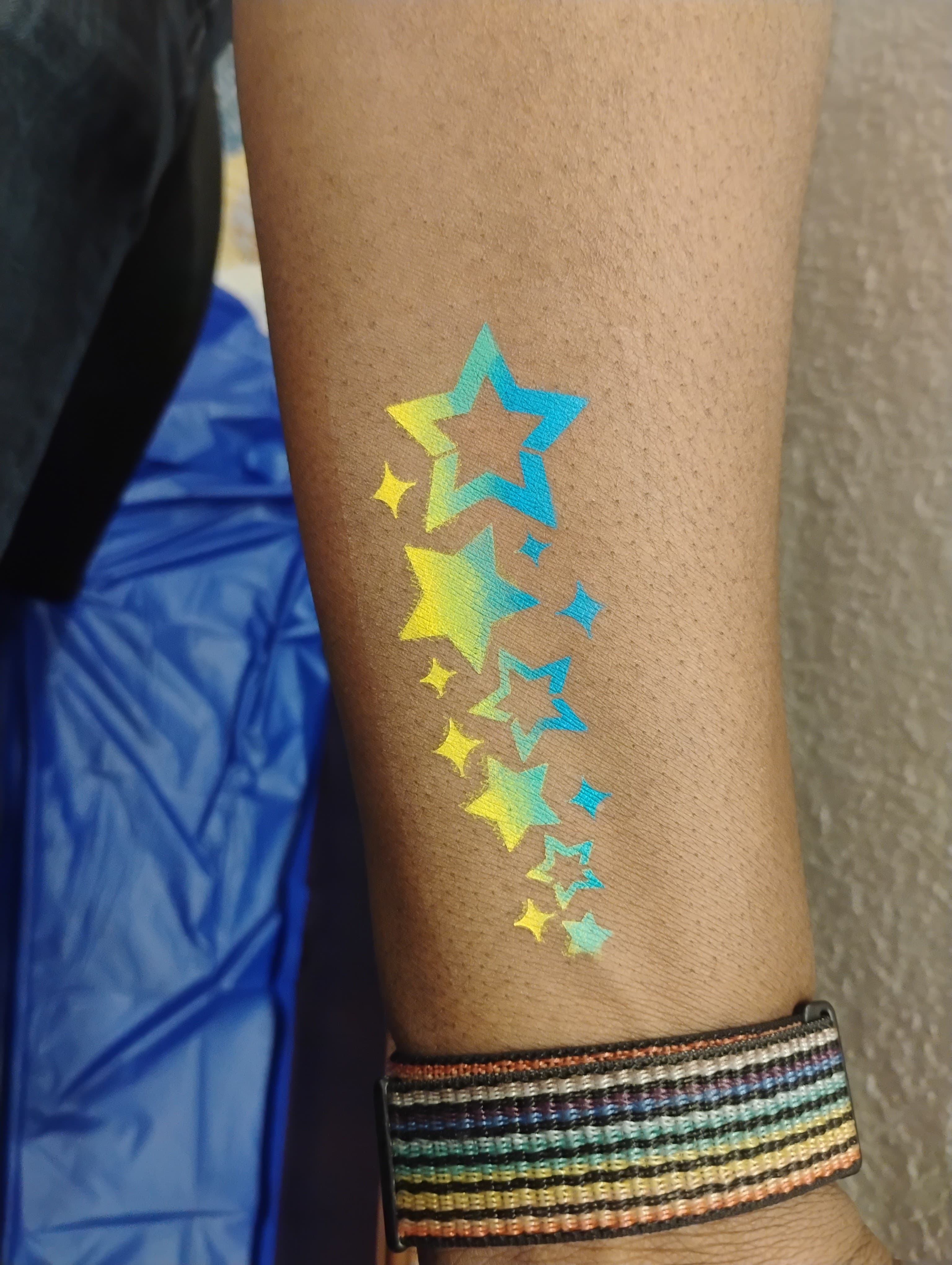 Holographic star cascade temporary tattoo on arm
