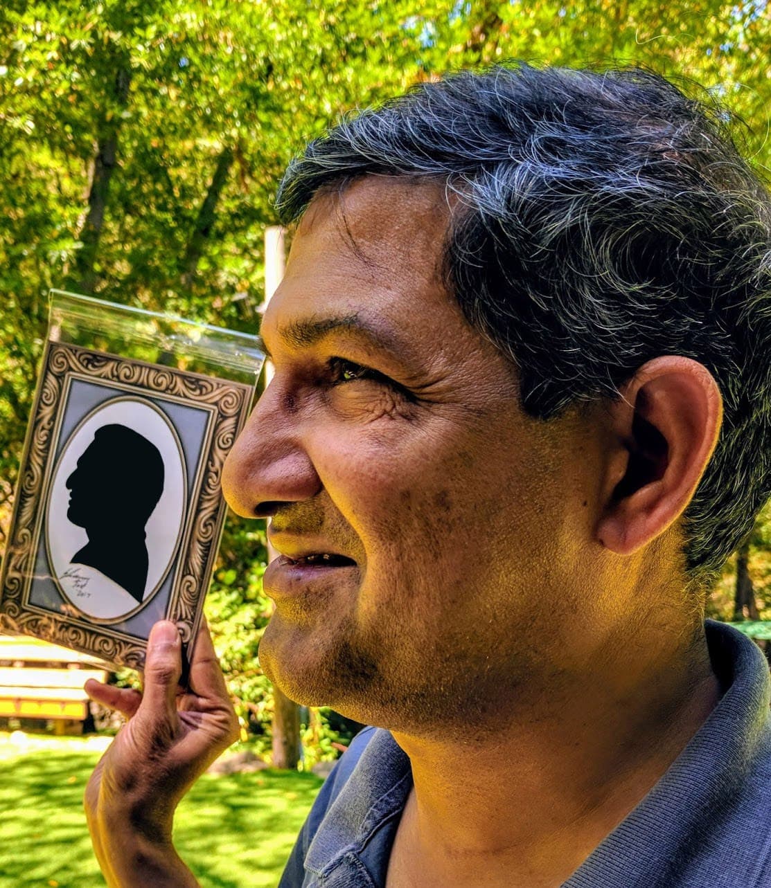 Guest holding a framed cut-paper silhouette of their profile
