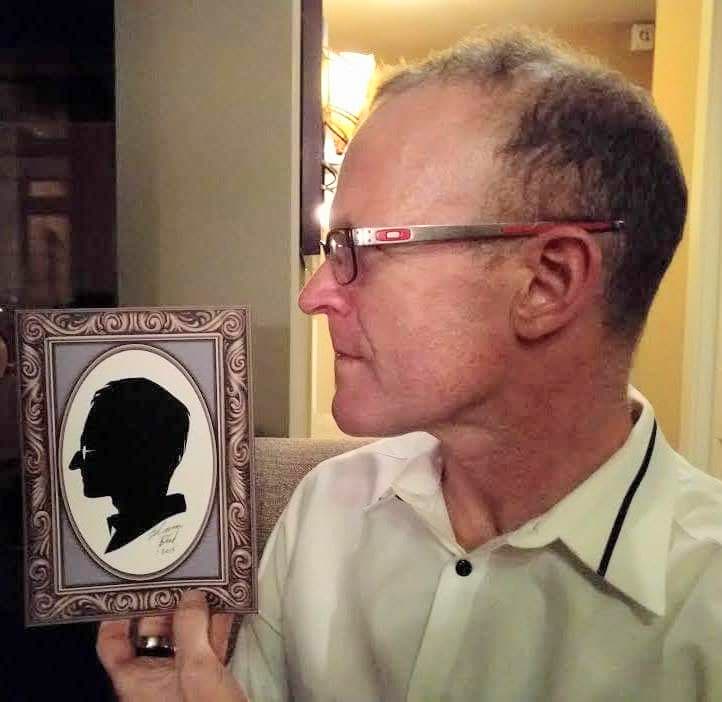 Guest comparing himself to his silhouette portrait